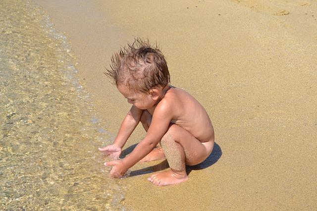 copil dezbracat pe plaja